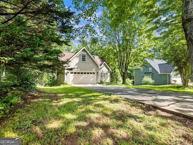 view of front facade featuring driveway, a front yard, and an attached garage