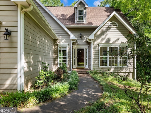 entrance to property featuring a shingled roof