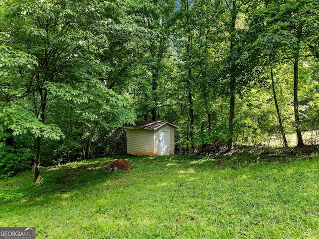 6212 Germantown Dr, Flowery Branch, GA 30542 - view of grassy yard with a storage shed and a forest view