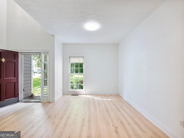 entryway featuring wood finished floors, baseboards, and a textured ceiling