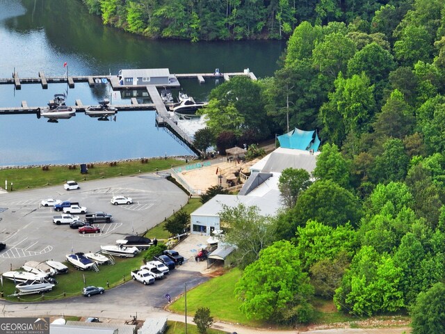 drone / aerial view of a nearby body of water and a forest