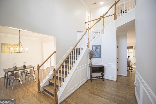 2019 Chelton Way SE, Smyrna, GA 30080 - staircase with a chandelier, ornamental molding, a high ceiling, and wood finished floors