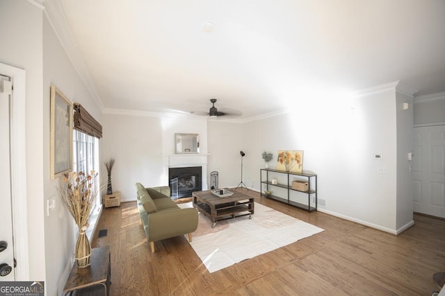 2019 Chelton Way SE, Smyrna, GA 30080 - living area featuring ornamental molding, a glass covered fireplace, wood finished floors, ceiling fan, and baseboards