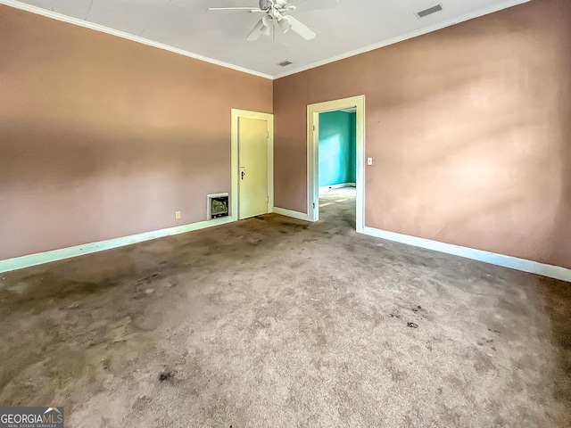 spare room featuring ceiling fan, carpet, baseboards, ornamental molding, and visible vents