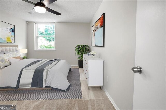 2965 Pharr Ct S Unit 110, Atlanta, GA 30305 - bedroom featuring light carpet, baseboards, a textured ceiling, and ceiling fan