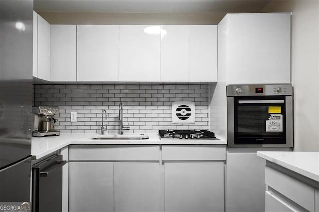 2965 Pharr Ct S Unit 110, Atlanta, GA 30305 - kitchen featuring white cabinets, stainless steel appliances, a sink, and tasteful backsplash