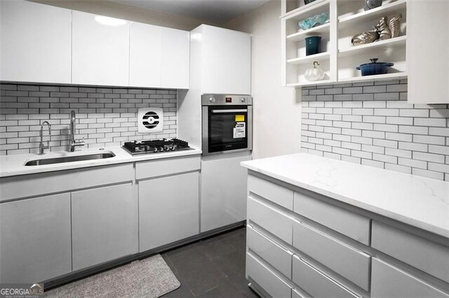 2965 Pharr Ct S Unit 110, Atlanta, GA 30305 - kitchen featuring oven, open shelves, a sink, gas cooktop, and decorative backsplash