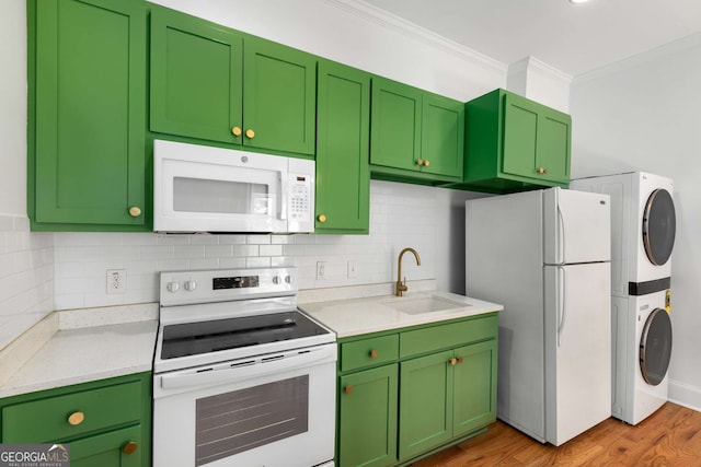 69 Hogue St NE, Atlanta, GA 30312 - kitchen with white appliances, estacked washer and dryer, a sink, ornamental molding, and light countertops