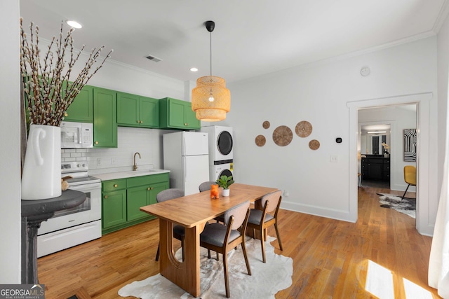 69 Hogue St NE, Atlanta, GA 30312 - kitchen with green cabinets, white appliances, stacked washing machine and dryer, crown molding, and backsplash