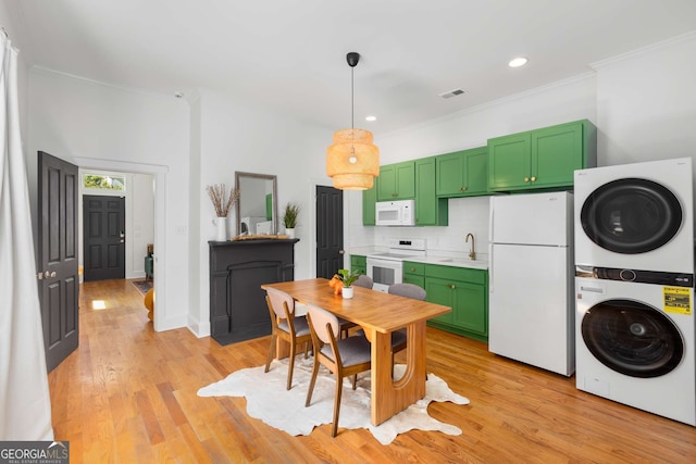 69 Hogue St NE, Atlanta, GA 30312 - kitchen with white appliances, green cabinetry, stacked washer / drying machine, a sink, and light countertops