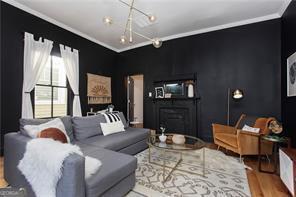 69 Hogue St NE, Atlanta, GA 30312 - living room with crown molding, wood finished floors, and a chandelier