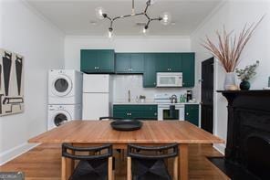 69 Hogue St NE, Atlanta, GA 30312 - dining space featuring stacked washer / drying machine, a chandelier, ornamental molding, and baseboards