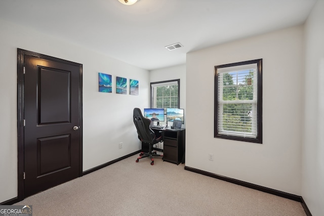 office area with baseboards, visible vents, and light colored carpet