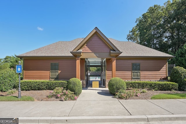 view of front of home featuring a gate and a shingled roof