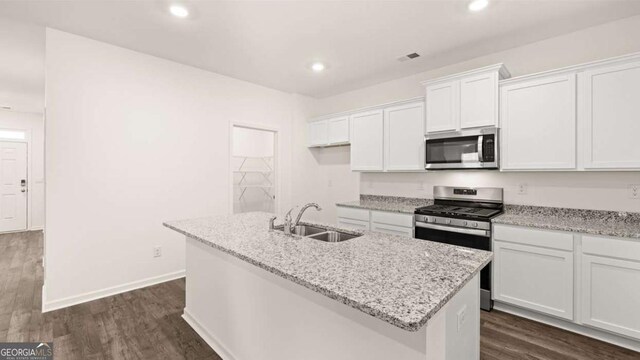 1416 Clear Pond Ln, Dacula, GA 30019 - kitchen with appliances with stainless steel finishes, a sink, white cabinetry, an island with sink, and dark wood-style floors