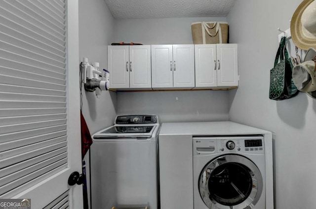 2820 Ashton Tree Ct, Dacula, GA 30019 - laundry area featuring washing machine and clothes dryer, cabinet space, and a textured ceiling