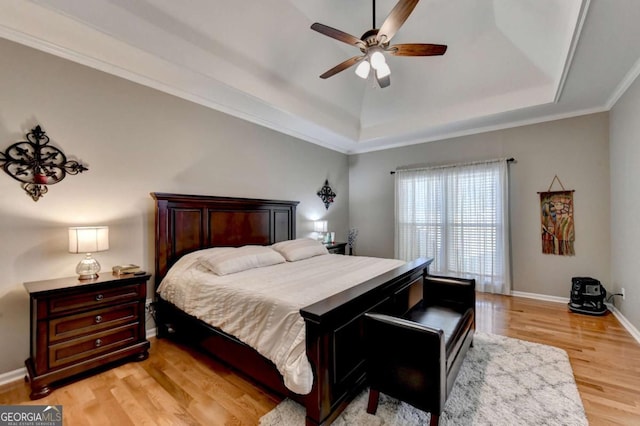 2820 Ashton Tree Ct, Dacula, GA 30019 - bedroom with crown molding, a ceiling fan, a tray ceiling, light wood-style flooring, and baseboards