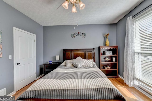 2820 Ashton Tree Ct, Dacula, GA 30019 - bedroom with light wood finished floors, a ceiling fan, and baseboards