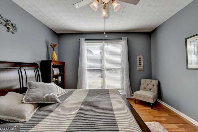 2820 Ashton Tree Ct, Dacula, GA 30019 - bedroom with wood finished floors, a textured ceiling, baseboards, and multiple windows