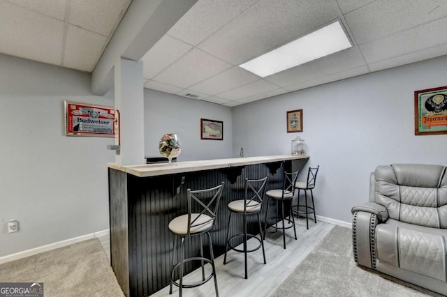 2820 Ashton Tree Ct, Dacula, GA 30019 - bar featuring bar area, baseboards, wood finished floors, and a paneled ceiling