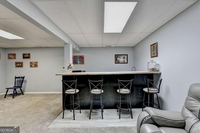 2820 Ashton Tree Ct, Dacula, GA 30019 - bar featuring baseboards, a paneled ceiling, carpet flooring, and wet bar