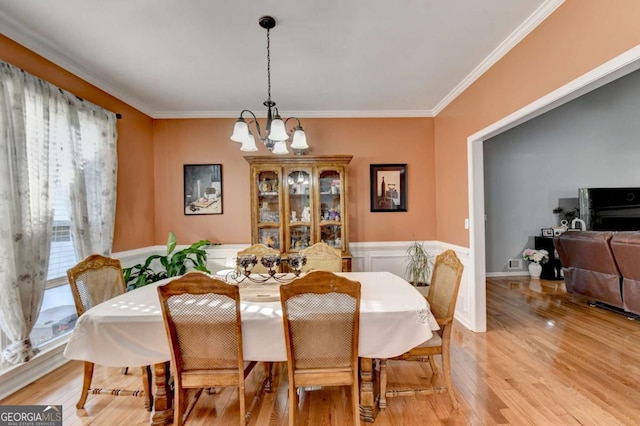 2820 Ashton Tree Ct, Dacula, GA 30019 - dining space featuring ornamental molding, a notable chandelier, a wainscoted wall, and light wood-style flooring