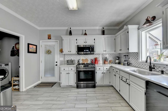 2820 Ashton Tree Ct, Dacula, GA 30019 - kitchen with backsplash, light countertops, a sink, appliances with stainless steel finishes, and washer / clothes dryer