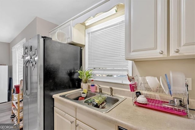 992 Old Holcomb Bridge Rd, Roswell, GA 30076 - kitchen with freestanding refrigerator, plenty of natural light, white cabinetry, and a sink