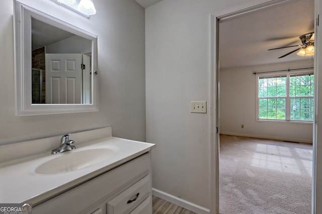 bathroom featuring vanity, ceiling fan, and baseboards