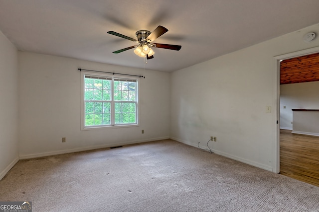 carpeted empty room with visible vents, baseboards, and ceiling fan