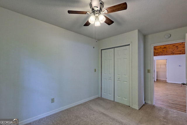 unfurnished bedroom with baseboards, a closet, and light colored carpet