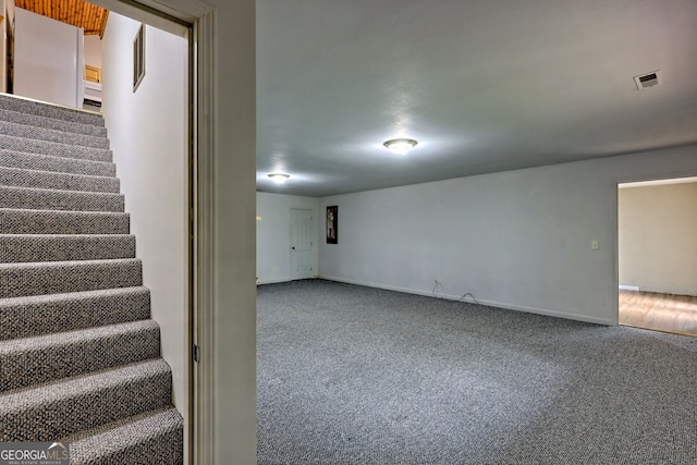 basement with visible vents, stairs, carpet floors, and baseboards