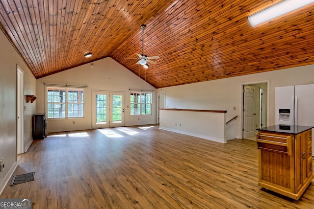 unfurnished living room featuring a ceiling fan, visible vents, light wood-type flooring, baseboards, and lofted ceiling