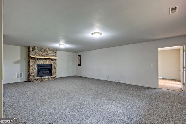 unfurnished living room with carpet floors, baseboards, and a fireplace