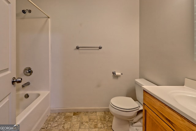 full bathroom with stone finish flooring, baseboards, vanity, toilet, and  shower combination