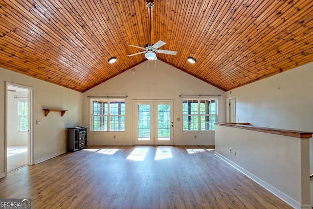 unfurnished living room with a healthy amount of sunlight, baseboards, a ceiling fan, and wood finished floors