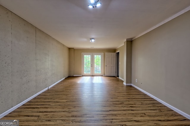 spare room featuring baseboards and wood finished floors