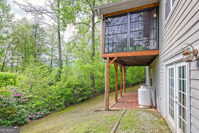 view of yard with french doors and a sunroom