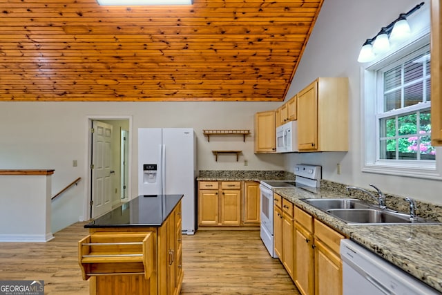 kitchen with light brown cabinets, white appliances, light wood-style floors, a sink, and vaulted ceiling