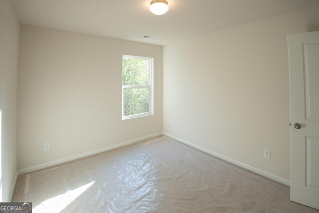 carpeted spare room featuring visible vents and baseboards