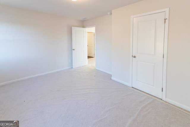 carpeted spare room featuring baseboards