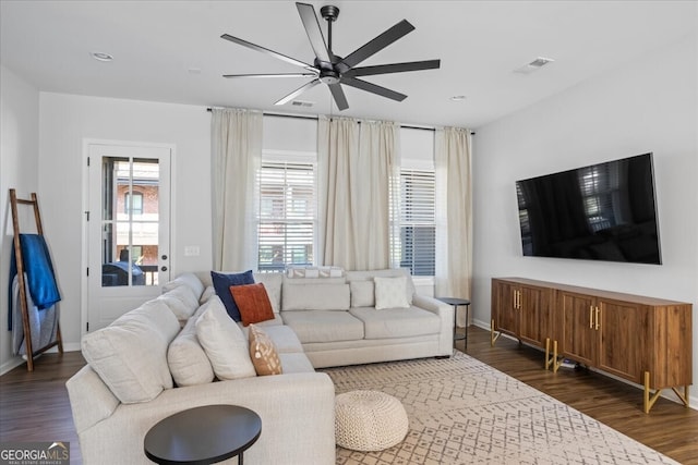 living room featuring baseboards, visible vents, a ceiling fan, and dark wood-style floors
