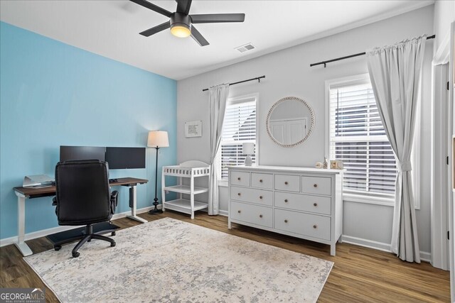 office space with plenty of natural light, a ceiling fan, and wood finished floors