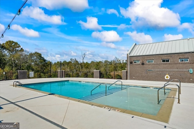 pool featuring fence and a patio area