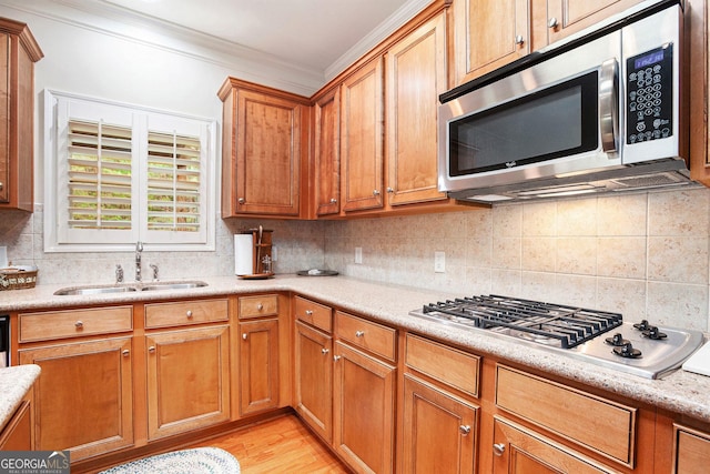 kitchen featuring crown molding, light countertops, tasteful backsplash, a sink, and stainless steel appliances