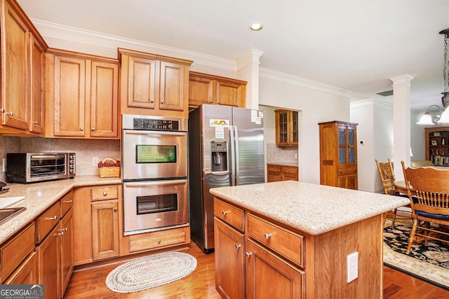 kitchen featuring a kitchen island, crown molding, light wood-type flooring, a toaster, and stainless steel appliances