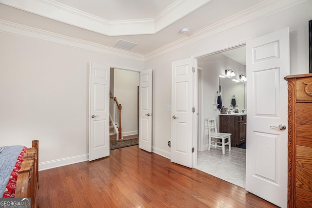 bedroom featuring baseboards, ornamental molding, and wood finished floors