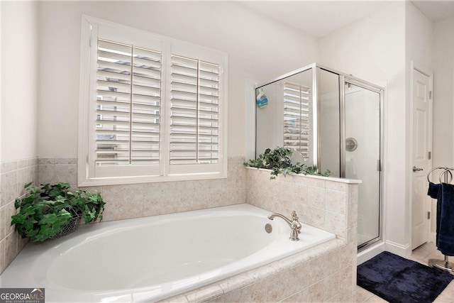 bathroom featuring a garden tub and a shower stall