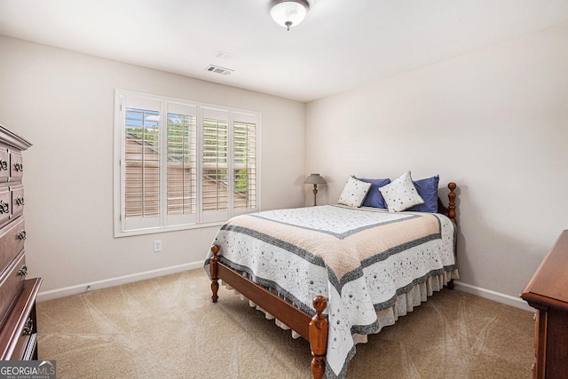 carpeted bedroom featuring baseboards and visible vents