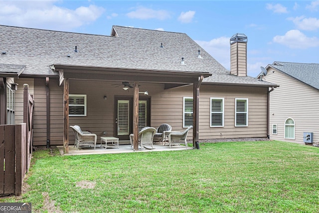 back of house featuring fence, a chimney, a patio area, a ceiling fan, and a yard